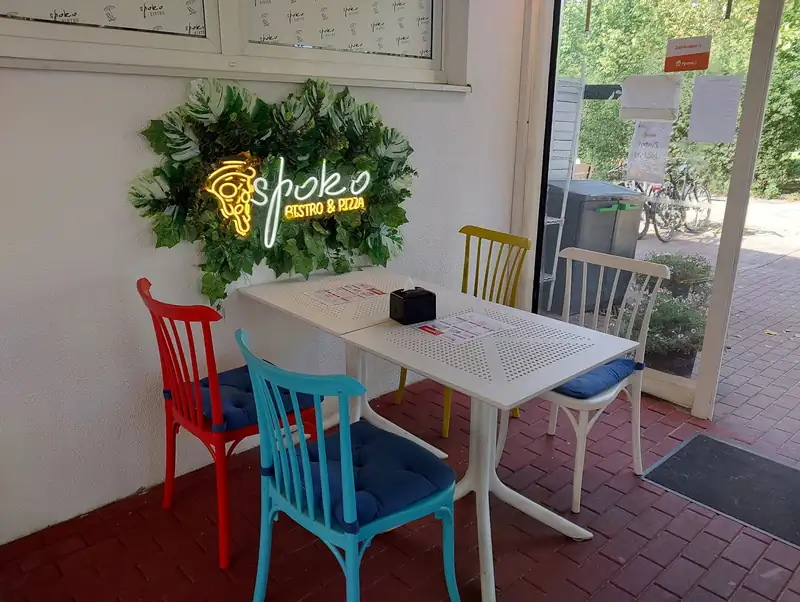 Neon „spoko BISTRO & PIZZA” w wieńcu z liści